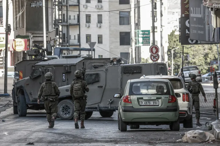 جنود الاحتلال يغلقون شارعا خلال عملية لإغلاق مكاتب جمعية التضامن الخيرية في مدينة نابلس (الفرنسية)