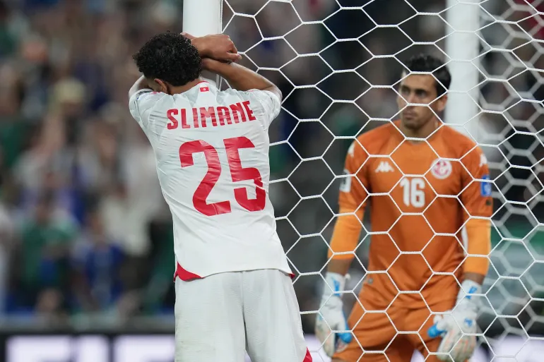 لاعب منتخب تونس أنيس بن سليمان والحارس أيمن دحمان بعد الهدف الرابع لليابان (أسوشيتد برس)