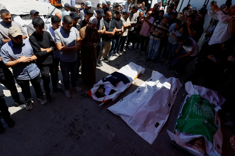 مشيعون يصلون على جثامين ثلاثة فلسطينيين استشهدوا بغارة إسرائيلية وسط قطاع غزة الأسبوع الماضي (رويترز)