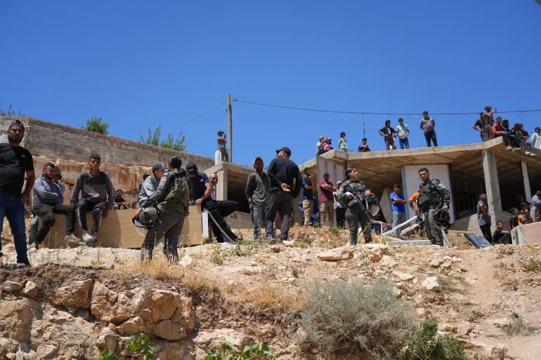 فلسطينيون يراقبون هدم منزل عائلة مسعف من مكان قريب