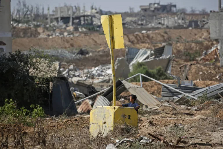 فتى فلسطيني قرب علامة "الخط الأصفر" شرقي دير البلح بقطاع غزة يوم 22 يوليو/تموز 2026 (الفرنسية)