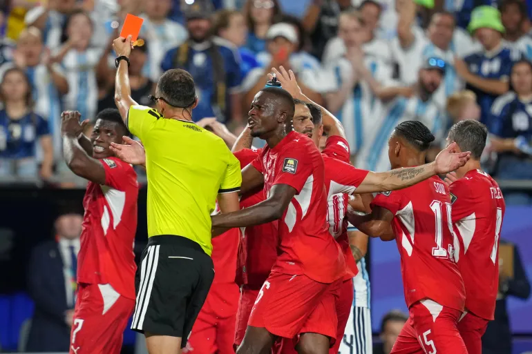 الحكم البرتغالي جواو بينهيرو يشهر البطاقة الحمراء في وجه السويسري بريل إمبولو خلال مباراة ربع نهائي كأس العالم 2026 بين الأرجنتين وسويسرا (أسوشيتد برس)