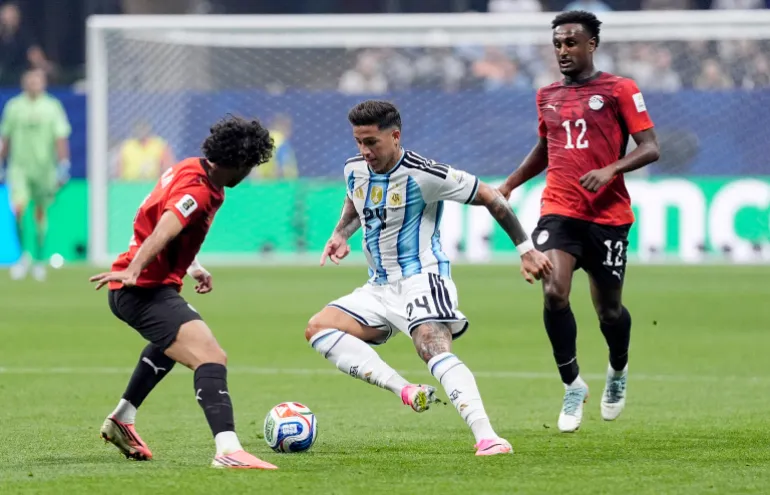 نزو فرنانديز لاعب الأرجنتين في مواجهة محمد هاني وهيسم حسن لاعبي مصر (رويترز)