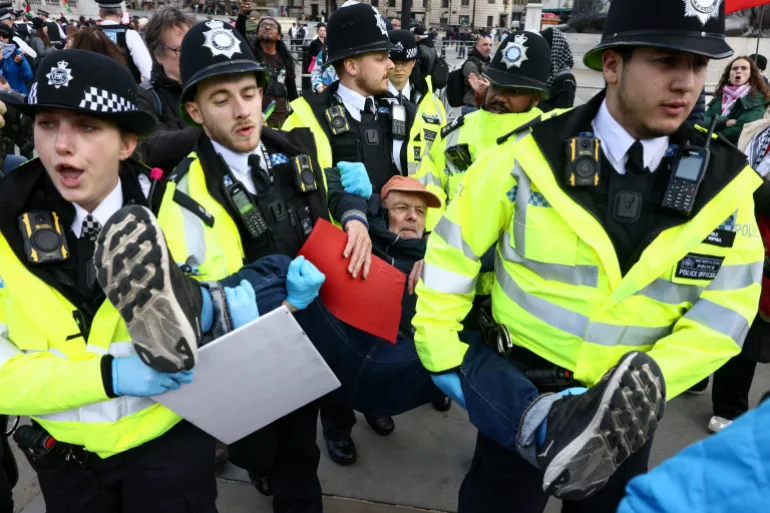 Police officers detain a protester at 'Everyone Day', a mass vigil and sign-holding event in Trafalgar Square organised by Defend Our Juries to demand the lifting of the ban on Palestine Action, in London, Britain, April 11, 2026. REUTERS/Jack Taylor
المعتقلون يواجهون تهما تتعلق بدعم منظمة محظورة (رويترز)