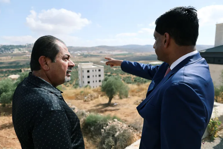 النائب الأمريكي رو خانا يتحدث مع أحد سكان بلدة ترمسعيا الفلسطينية قرب رام الله خلال زيارته للضفة الغربية المحتلة في 9 يوليو/تموز 2026 (رويترز)