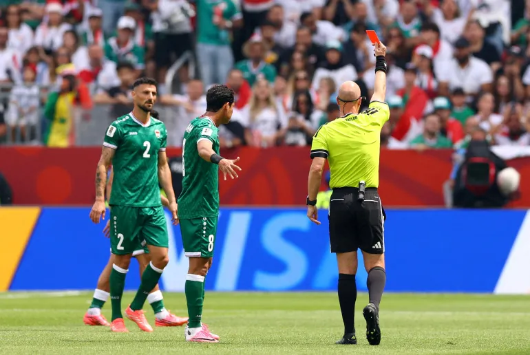 الحكم أنتوني تايلور يشهر البطاقة الحمراء في وجه لاعب منتخب العراق ريبين سولاكا (رويترز)
