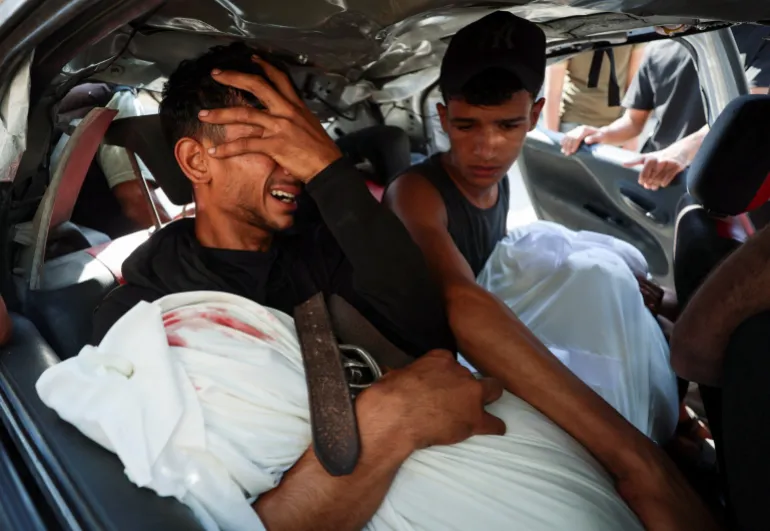 Palestinian man, Hamas Al-Hdabi, mourns holding the body of his father, Sohail, who was killed in an Israeli strike, as Hamas sits inside a car during the funeral, in Gaza City, July 16, 2026. REUTERS/Dawoud Abu Alkas
استشهاد أكثر من 21 ألف طفل منذ بداية الإبادة في غزة (رويترز)
