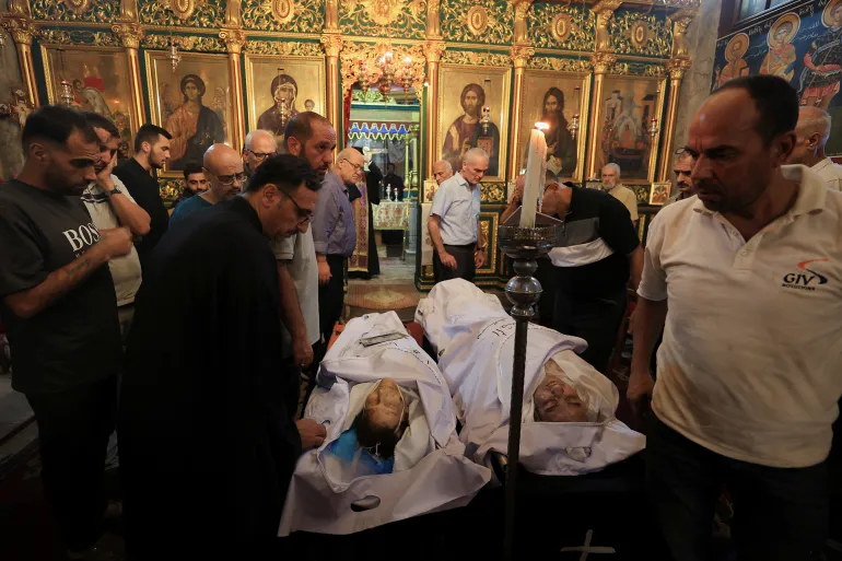 مشيعون يحضرون جنازة المسيحيين الفلسطينيين الذين قُتلوا في غارة إسرائيلية على كنيسة العائلة المقدسة، في مدينة غزة، 17 يوليو/تموز 2025 (رويترز)