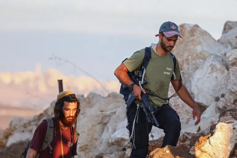 مستوطنون خلال مسيرة بين قريتي "صرة" و"تل" الفلسطينيتين جنوب غرب نابلس في الضفة الغربية المحتلة (الفرنسية)