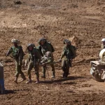 جنود إسرائيليون يجلون جنديا خلال تدريبات عسكرية سابقة شمال مدينة إيلات (غيتي-أرشيف)